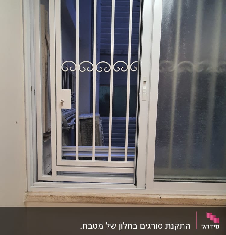 חלון עם סורגים לבנים ודלת הזזה מזכוכית